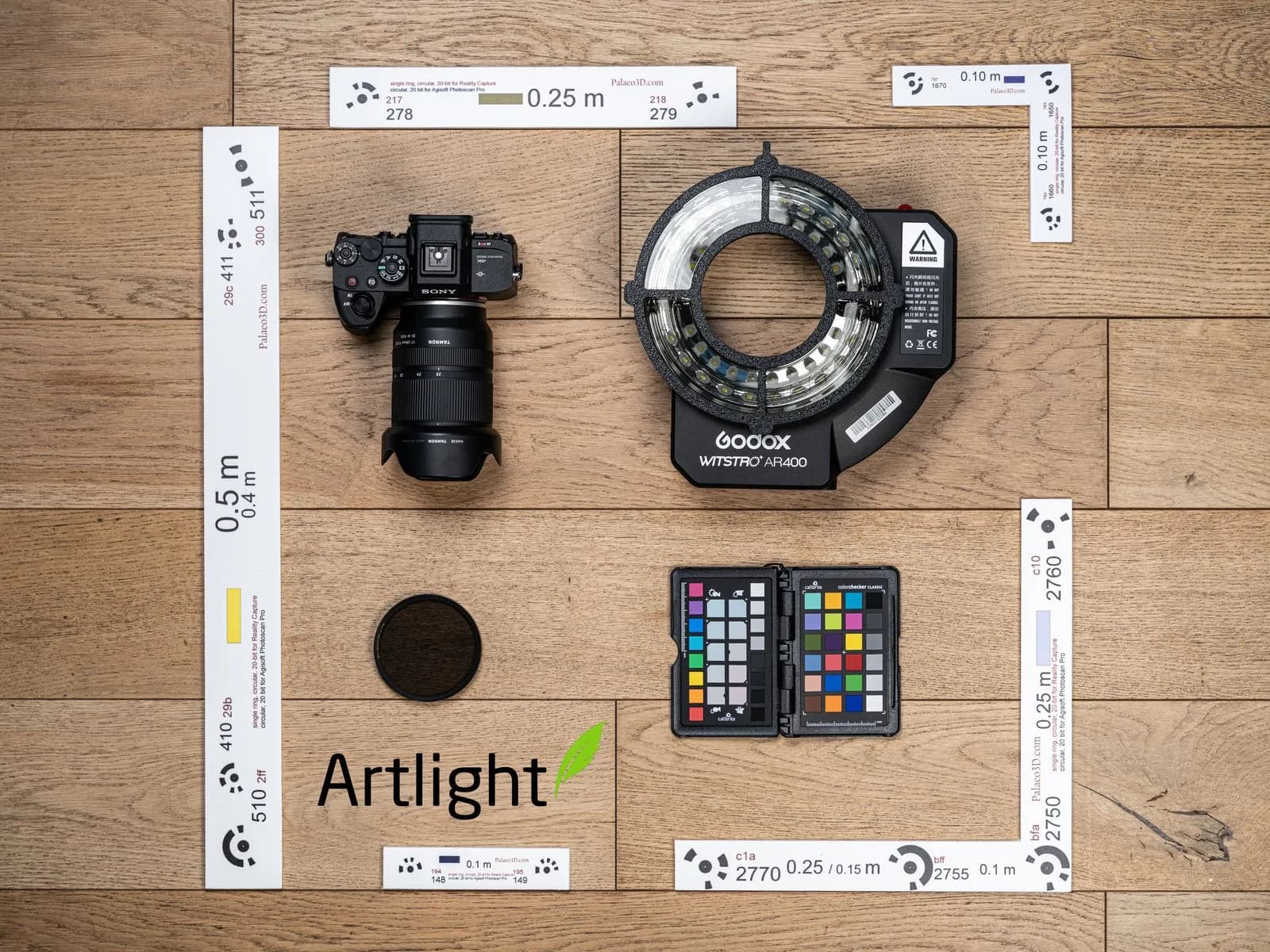 Le matériel de numérisation posé à plat : appareil photo, flash annulaire, filtre polarisant, charte colorimétrique et barres d'échelle